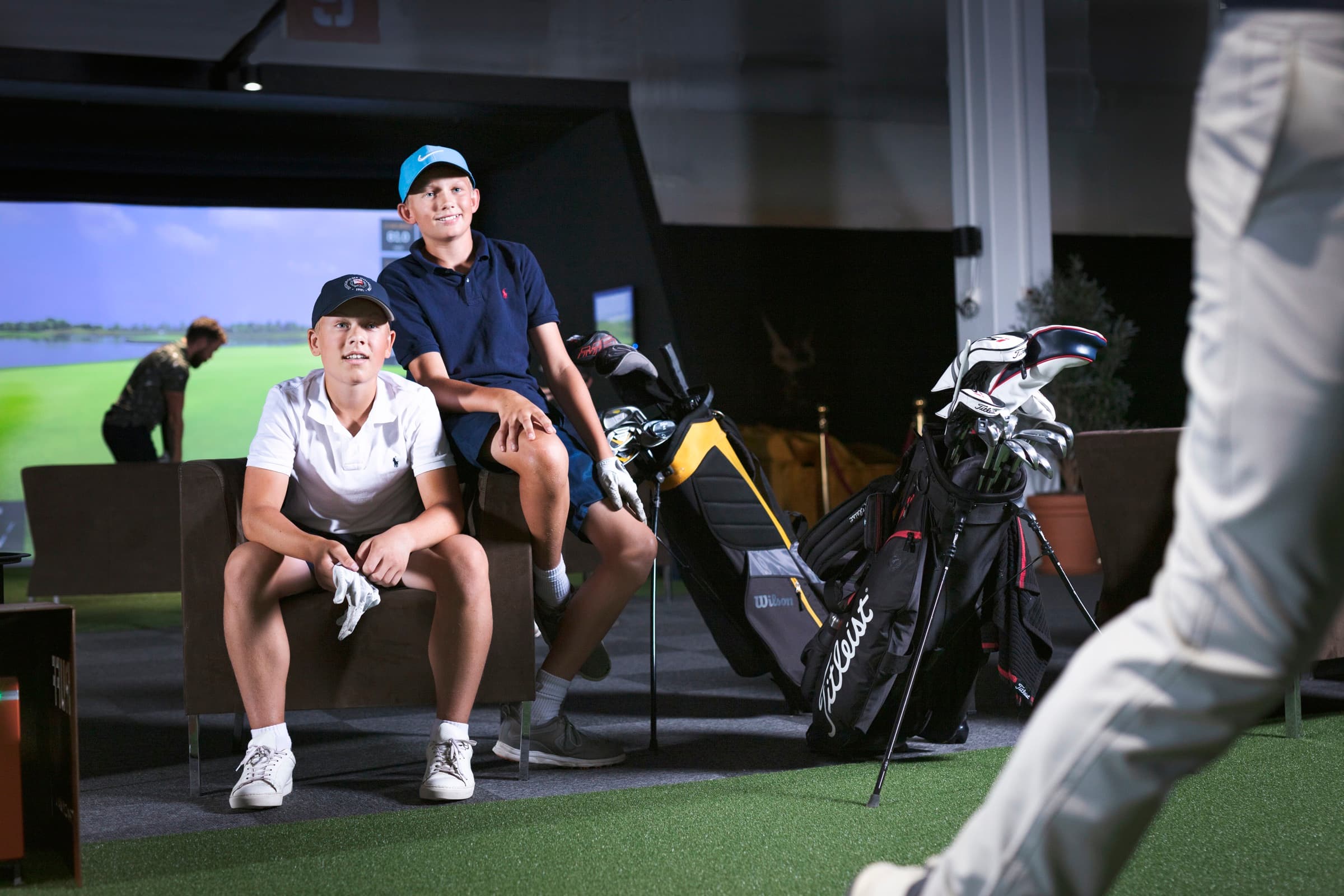 Hvid golfbold på en grøn filtmåtte med en tee ved siden af